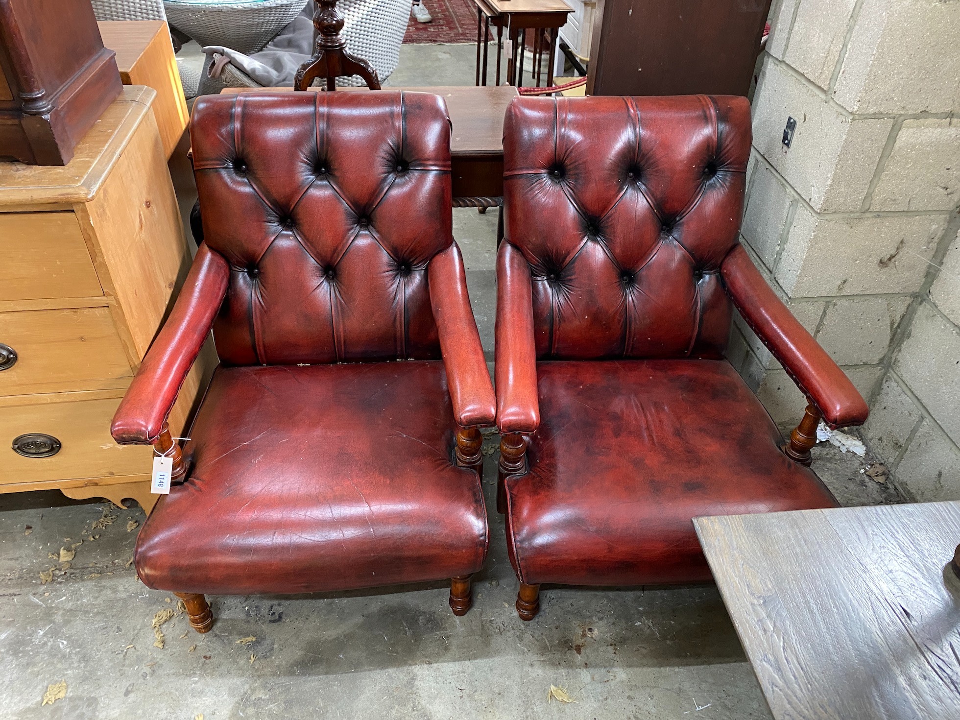 A pair of Victorian style button back burgundy leather Howard style open armchairs, width 69cm, depth 88cm, height 86cm